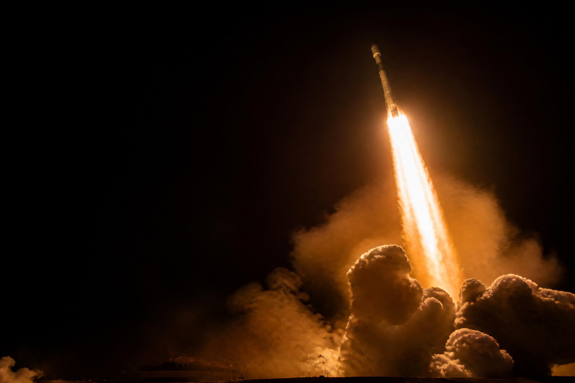 Rocket launching at full thrust into the night sky